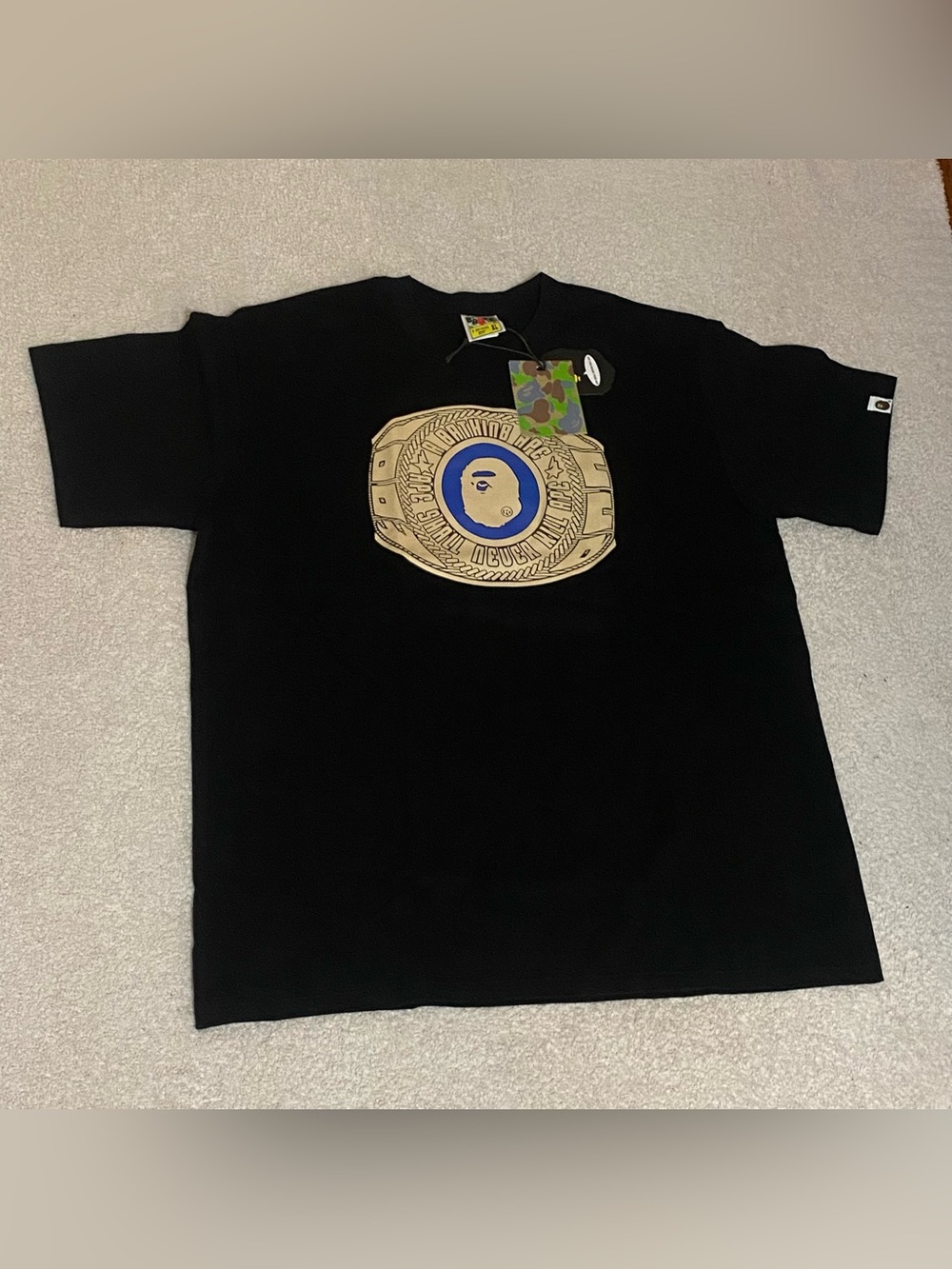 A Bathing Ape Bape Black Short Sleeve Tee with Gold Belt Graphic and Blue Emblem